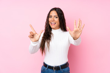 Young woman over isolated pink background counting seven with fingers