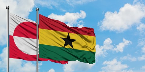 Greenland and Ghana flag waving in the wind against white cloudy blue sky together. Diplomacy concept, international relations.