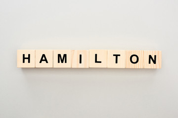 Wall Mural - top view of wooden blocks with Hamilton lettering on grey background