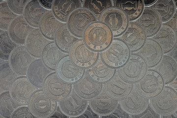 Wall Mural - Plane of many Japanese coins at 1 yen. Dark background or wallpaper. News about the economy, finances and interest rate of the central bank of Japan. View from above