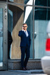 © LIGHTFIELD STUDIOS - handsome man in suit and glasses with hand in pocket talking on smartphone