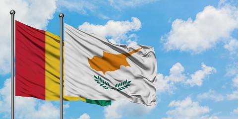 Guinea and Cyprus flag waving in the wind against white cloudy blue sky together. Diplomacy concept, international relations.