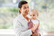 medicine, healthcare and pediatrics concept - smiling female pediatrician doctor or nurse holding baby girl patient at clinic or hospital