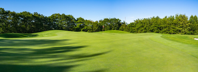 Wall Mural - Panorama View of Golf Course with beautiful putting green. Golf course with a rich green turf beautiful scenery.