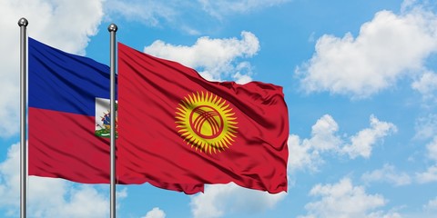 Haiti and Kyrgyzstan flag waving in the wind against white cloudy blue sky together. Diplomacy concept, international relations.