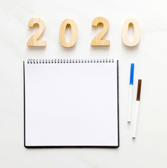 2020 wooden letters and blank notebook paper with copy space for text, new year background banner concept