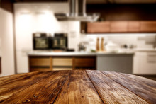 Wooden Table Background Of Free Space For Your Decoration And Blurred Background Of Kitchen. Copy Space.Dark Mood Interior. Kitchen Furniture. 