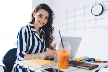 Sticker - Smiling woman using laptop in bright office