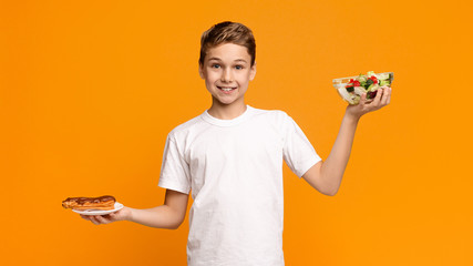 Teenager holding fresh salad and chocolate donut