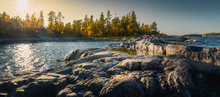 Beautiful Panorama Of A Rocky Shore. Nordic Sunrise Or Sunset.  Close-up Of  Big Stones