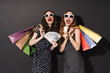 © Drobot Dean - Image of stylish women in sunglasses holding colorful shopping bags