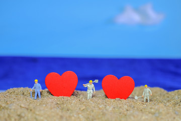 Wall Mural - Miniature worker with Heart sign on sea beach,love concept.