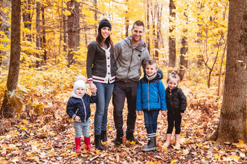 Wall Mural - A portrait of a young family in the autumn park