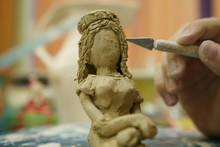 Photography Of Clay - Stained Girl Doing The Figurine Of A Girl Wth Long Hair. Concepts Of Handicraft And Creativity
