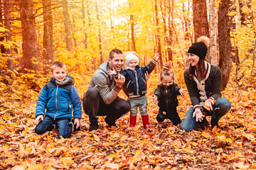 Wall Mural - A portrait of a young family in the autumn park