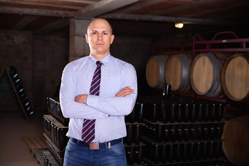 Sticker - Confident succesful man winemaker posing in own winery vault