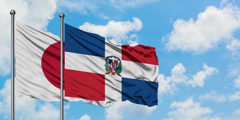 Japan and Dominican Republic flag waving in the wind against white cloudy blue sky together. Diplomacy concept, international relations.