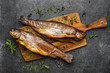 Smoked fish with spices on dark background