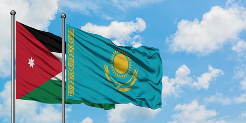 Jordan and Kazakhstan flag waving in the wind against white cloudy blue sky together. Diplomacy concept, international relations.