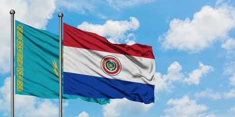 Kazakhstan and Paraguay flag waving in the wind against white cloudy blue sky together. Diplomacy concept, international relations.