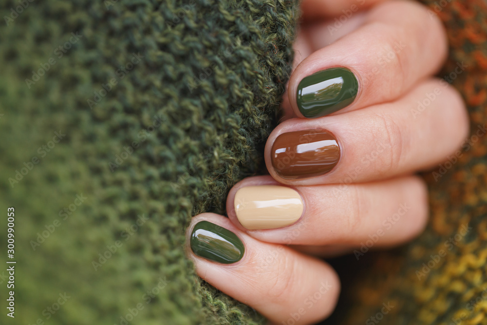 Autumn colors manicure on short round natural nails with green knitted scarf - obrazy, fototapety, plakaty 