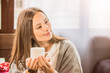 © de Art - a girl in a cafe holding a mug of coffee