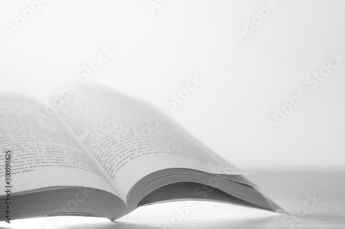 Fotomural Open book on wooden table and white background
