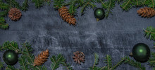 Frame Of Natural Fir Pine Branches And Cones And Green Baubles On Rustic Dark Black Grey Wooden Table - Christmas Background Panorama Banner Long - Top View