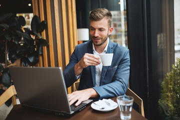 Male manager have break in cafe bar,using laptop