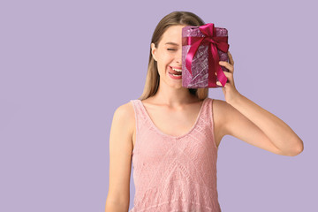 Poster - Grimacing woman with gift box on color background