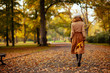 © Alliance - young woman with yellow leaves walking outside in autumn park