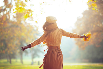 elegant woman with yellow leaves outdoors in autumn park