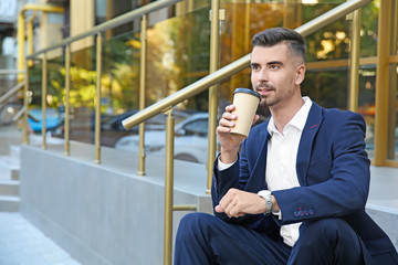 Poster - Portrait of handsome businessman with cup of coffee outdoors