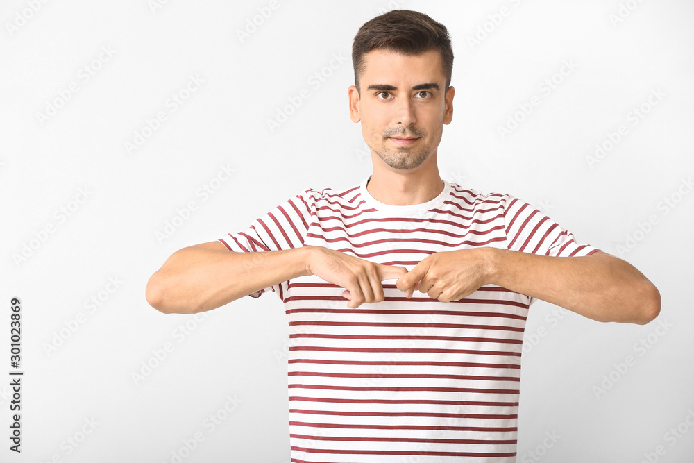 Young deaf mute man using sign language on white background