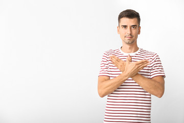 Wall Mural - Young deaf mute man using sign language on white background