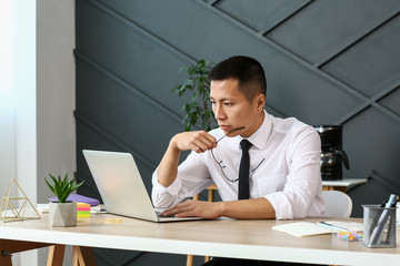 Asian businessman working on laptop in office