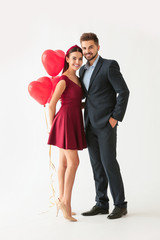 Poster - Portrait of beautiful young couple with air balloons on white background