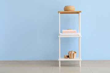 Poster - Shelf unit with bath supplies and towels near color wall