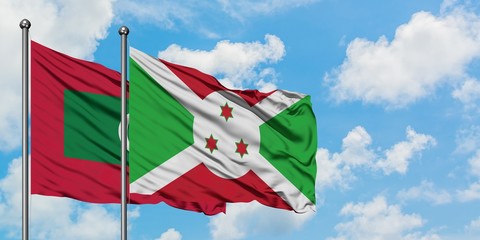 Maldives and Burundi flag waving in the wind against white cloudy blue sky together. Diplomacy concept, international relations.