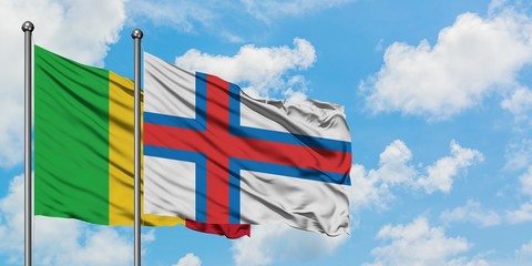 Mali and Faroe Islands flag waving in the wind against white cloudy blue sky together. Diplomacy concept, international relations.