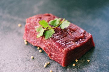 Raw meat beef steak with spices garlic on wooden cutting board and black background, top view - Fresh beef piece for steak or grilled barbecue