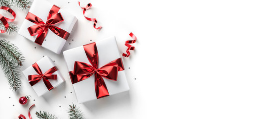 Wall Mural - merry christmas card made of fir branches, gift boxes, red decoration, sparkles and confetti on whit