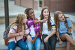 © Brocreative - Candid photo of a group of teenage girls socializing, laughing and talking together at school. A multi-ethnic group of real junior high aged students