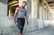 © elnariz - Lifestyle portrait of a male athlete with strong muscular body, stretching legs before running, urban exercise