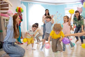 Happy children and their parents entertain and have fun with color balloons on birthday party