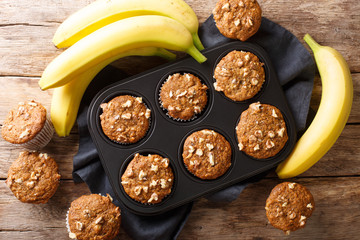 Wall Mural - Freshly baked banana walnuts muffins close-up in a baking dish. Horizontal top view