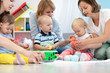 © Oksana Kuzmina - Toddler babies with moms in playroom in nursery