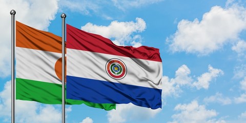 Niger and Paraguay flag waving in the wind against white cloudy blue sky together. Diplomacy concept, international relations.