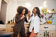 © AS Photo Family - Two african american female friends women spending time at kitchen with wine. Black girlfriends  relaxing at home and eat chocolate.