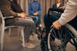 © AnnaStills - Close-up of senior disabled man sitting in wheelchair and visiting business meeting